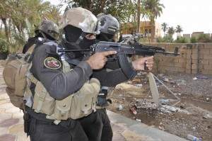Armed Iraqi security forces personnel take their positions during a patrol in the city of Ramadi