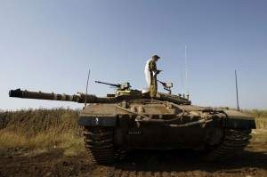 An Israeli soldier prays atop a tank close to the ceasefire line between Israel and Syria on the Israeli occupied Golan Heights