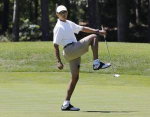 U.S. President Obama reacts after missing putt on the first green at golf course on Martha's Vineyard